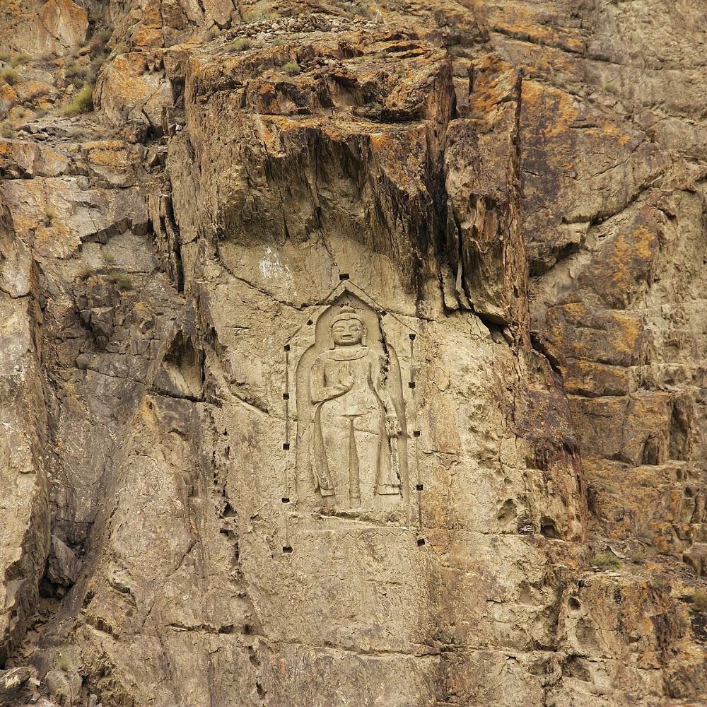 Kargah Buddha ancient rock carving on cliff face in Gilgit Baltistan Pakistan with mountain backdrop